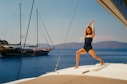 a woman in a bathing suit standing on a boat