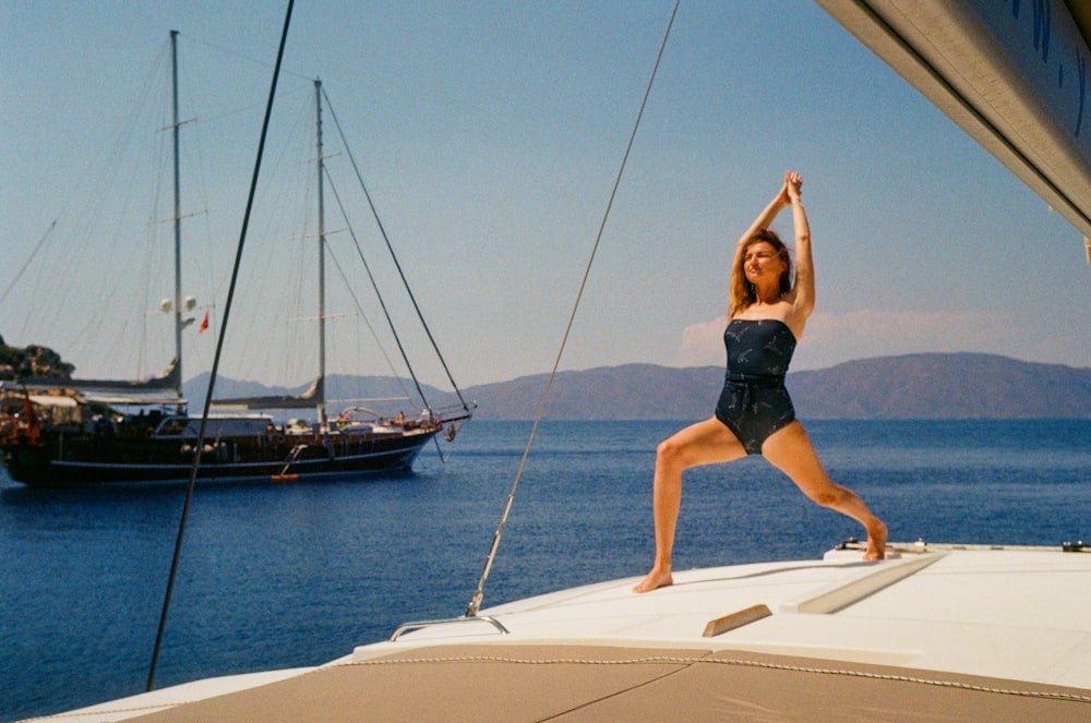 a woman in a bathing suit standing on a boat