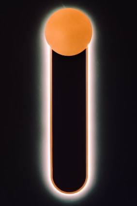 A sleek, minimalistic futuristic design interface with black background, geometric typography, and orange iridescent accents.