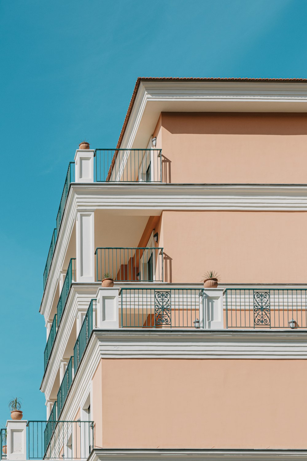 a pink building with balconies and balconies on the balconies