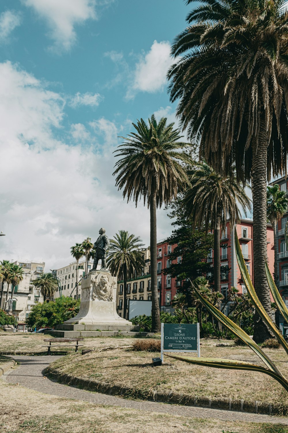 Une statue d’un homme entouré de palmiers