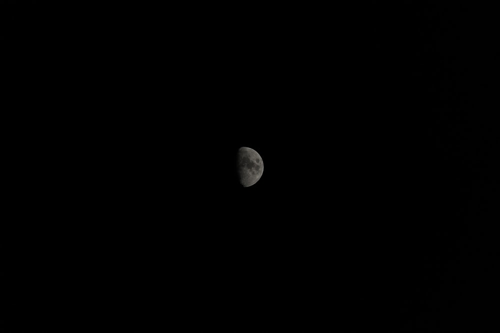 the moon is seen in the dark sky