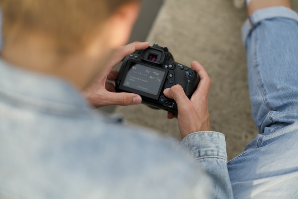 Un uomo che tiene una macchina fotografica tra le mani