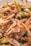 A close-up view of cooked shrimp mixed with chopped green onions. The shrimp is lightly browned, with visible eyes and seasoning, and the dish appears appetizing and fresh.