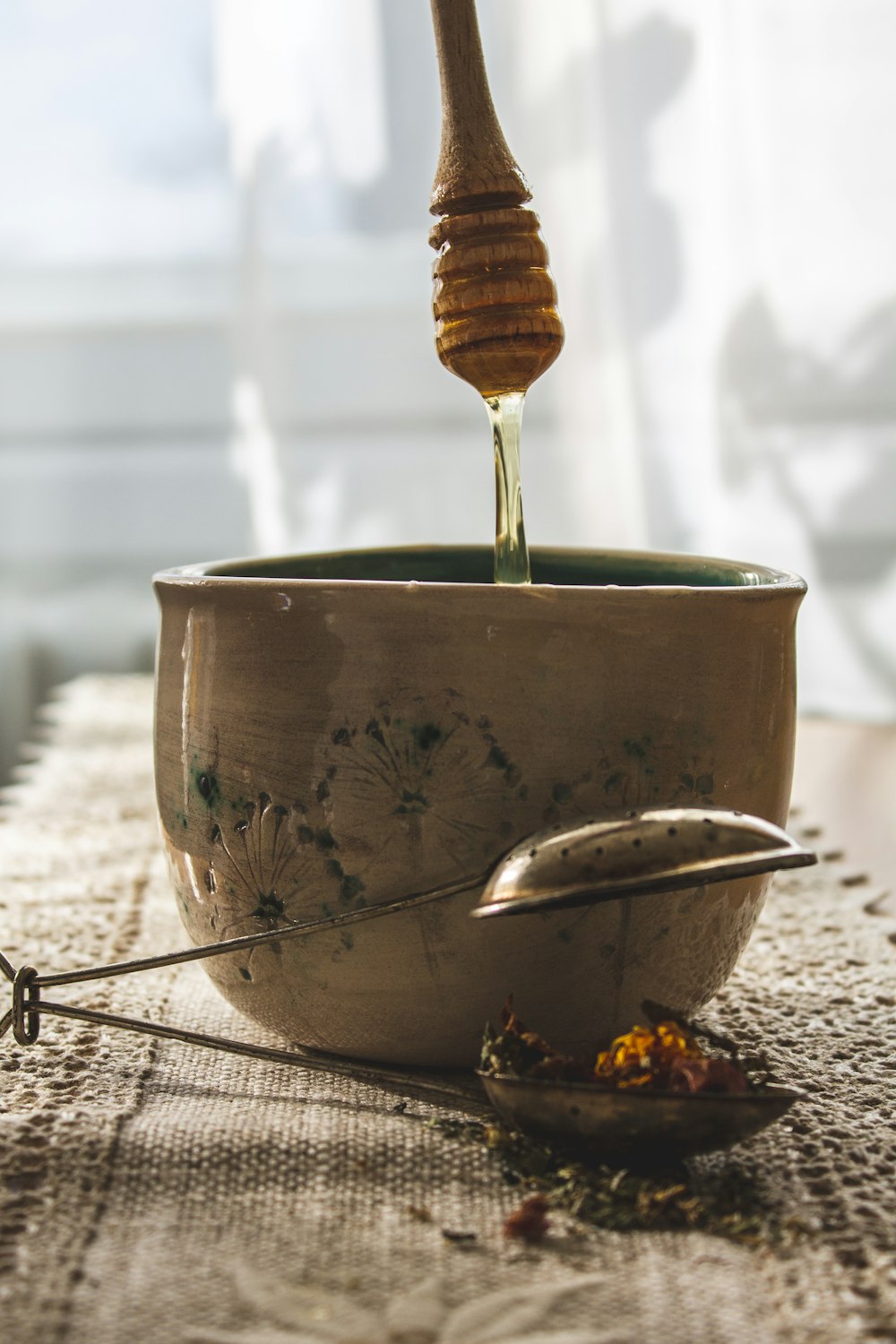 a spoon is pouring honey into a bowl