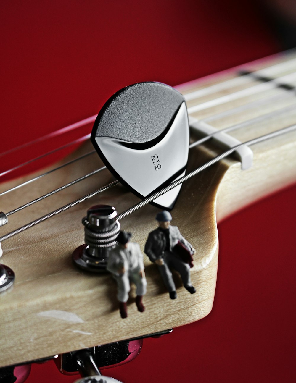 a close up of a guitar's neck with miniature people on it