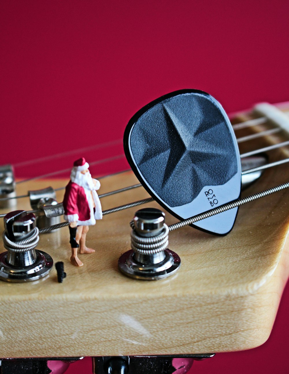 a miniature person standing on top of a guitar