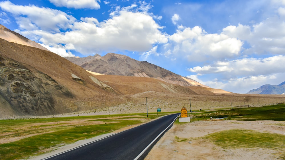 a road in the middle of a desert with mountains in the background