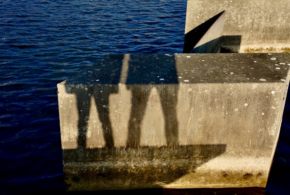 the shadow of two people on a concrete wall