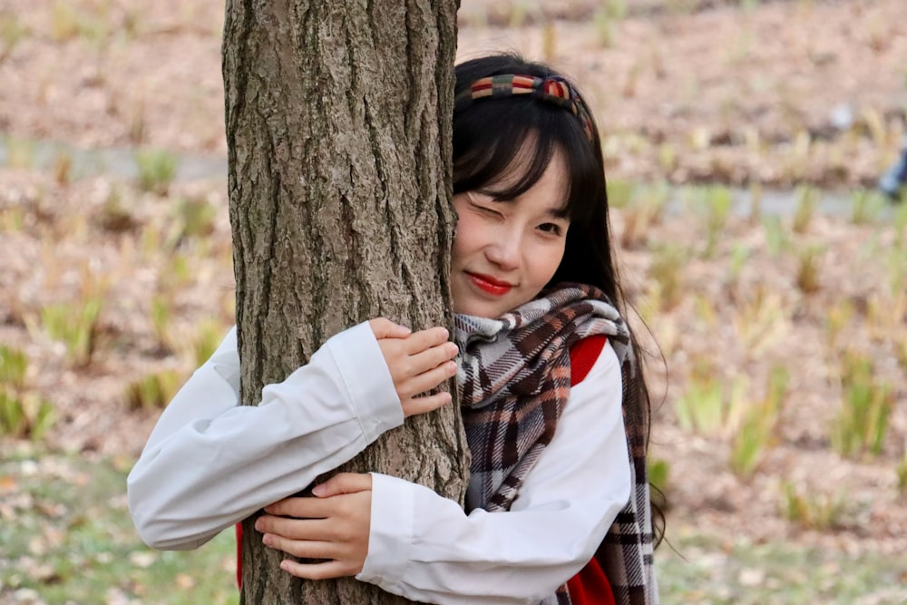 a woman hugging a tree in a park