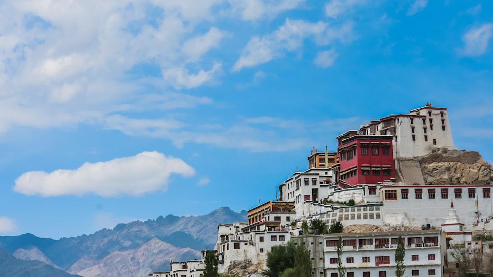 a group of buildings on a hill with mountains in the background