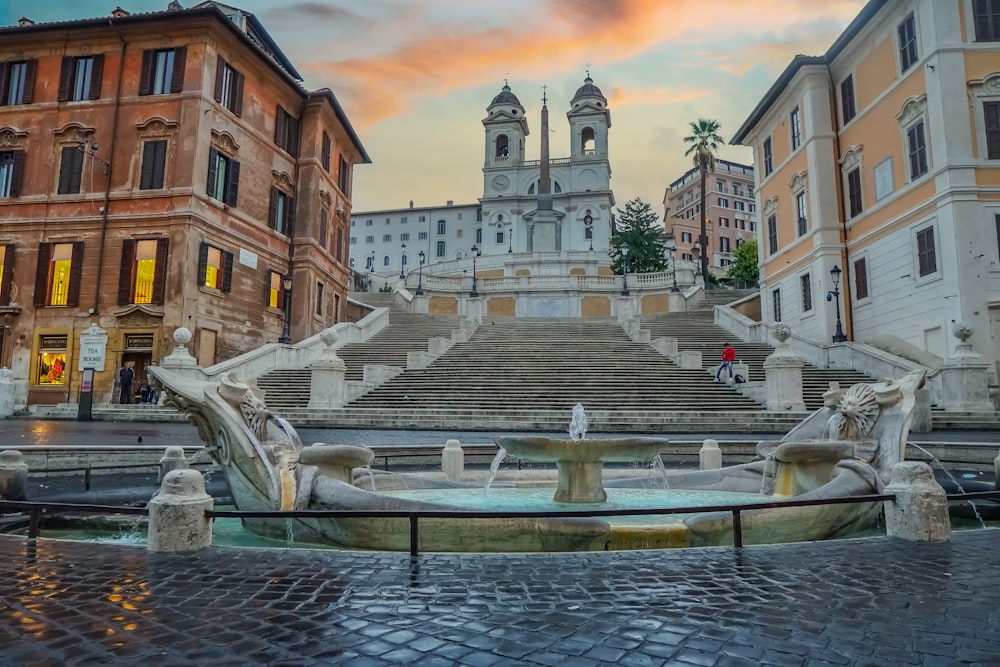 a fountain with a clock tower in the background