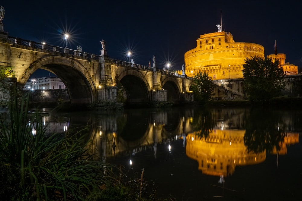 a bridge over a body of water with a castle in the background