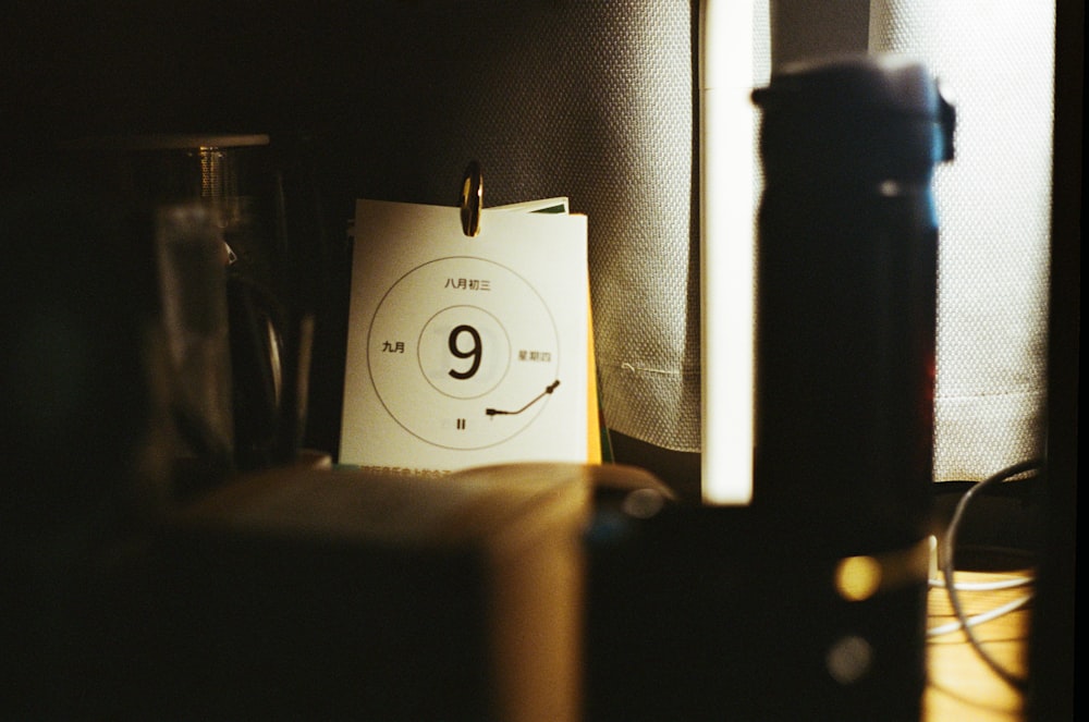 a note with the number nine on it next to a lamp