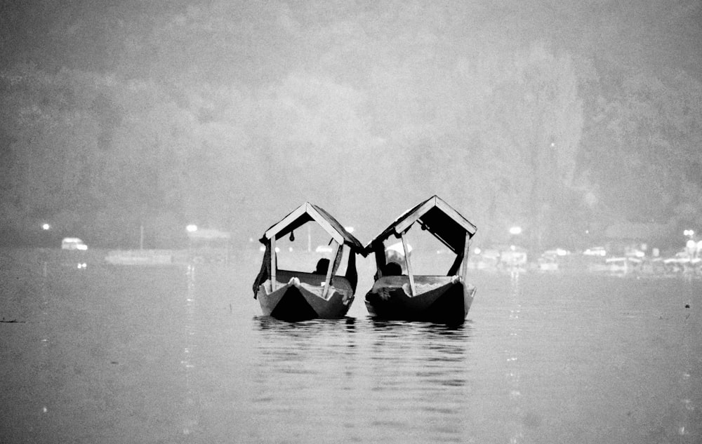 a couple of boats floating on top of a lake