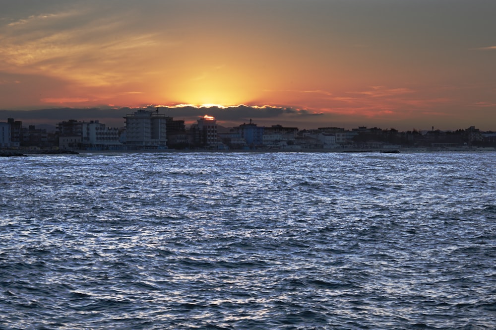 a large body of water with buildings in the background