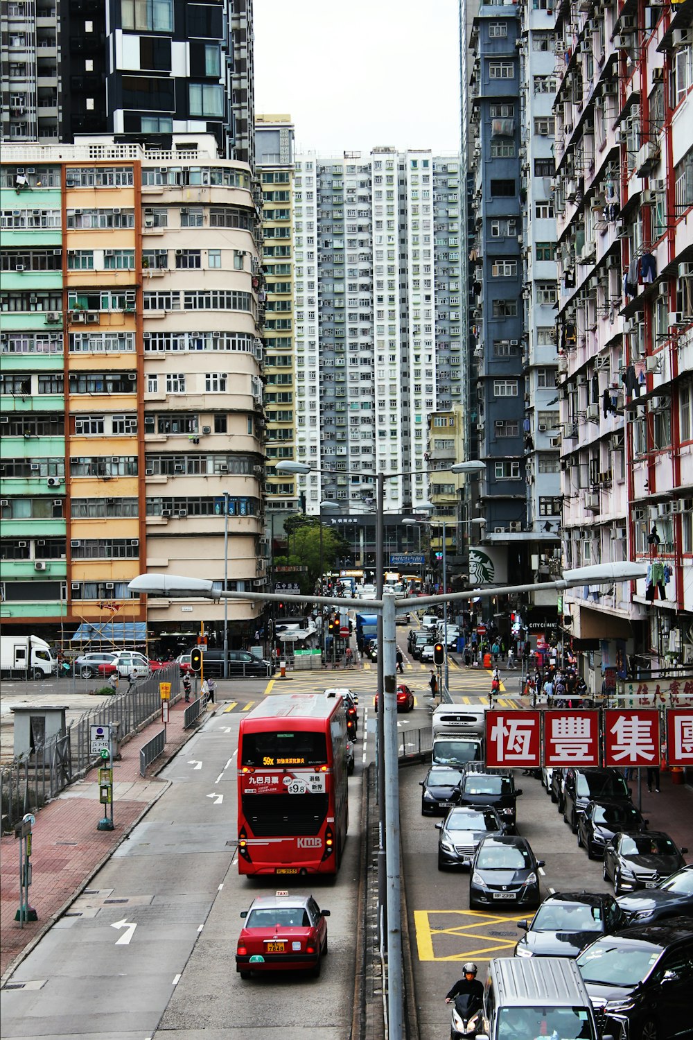 a red double decker bus driving down a city street