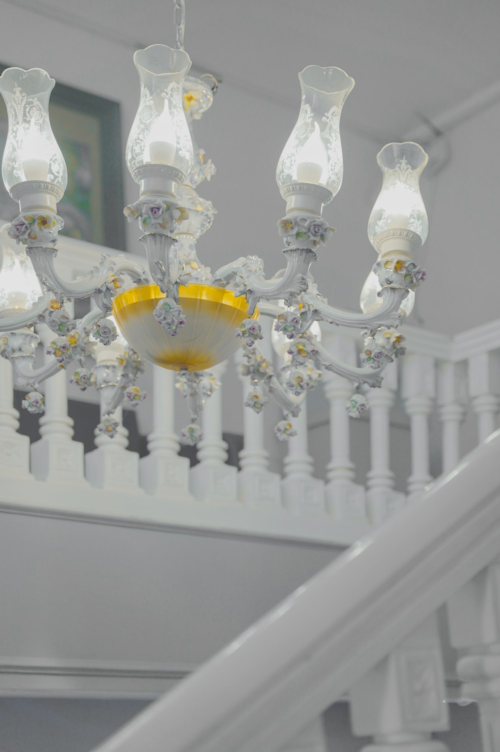 a chandelier hanging from a white banister