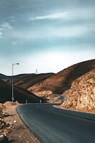 an empty road in the middle of a mountainous area
