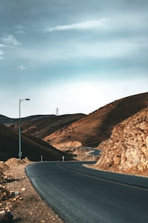 an empty road in the middle of a mountainous area