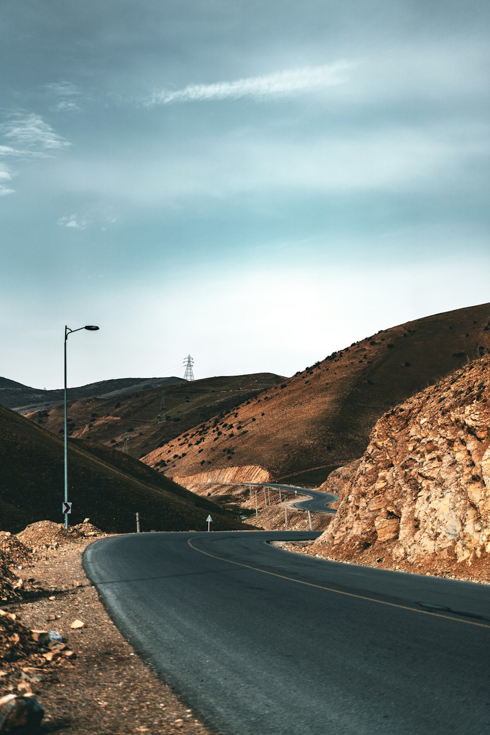 an empty road in the middle of a mountainous area