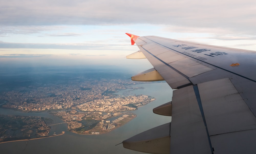 the wing of an airplane flying over a city