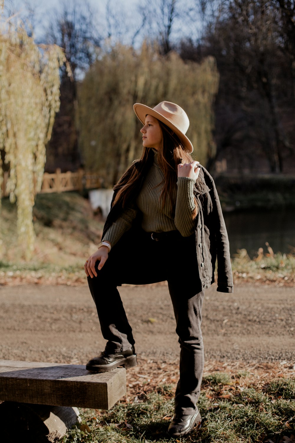 a woman sitting on a bench wearing a hat