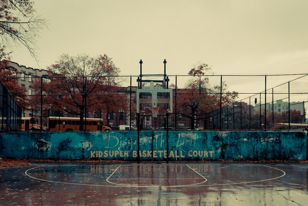 a basketball court with graffiti on the side of it