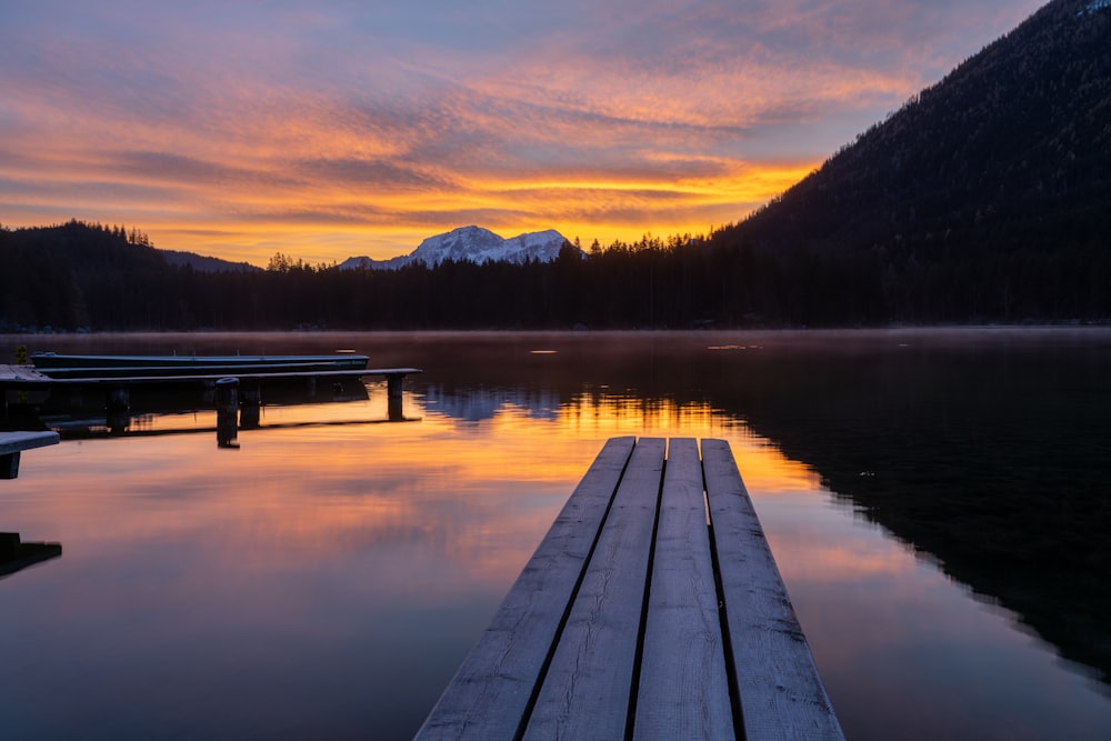 a dock sitting on top of a lake next to a mountain