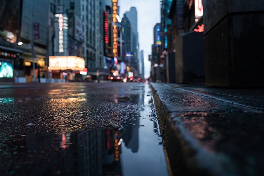 a wet city street with a puddle of water