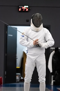 a man in a white suit holding a fishing rod