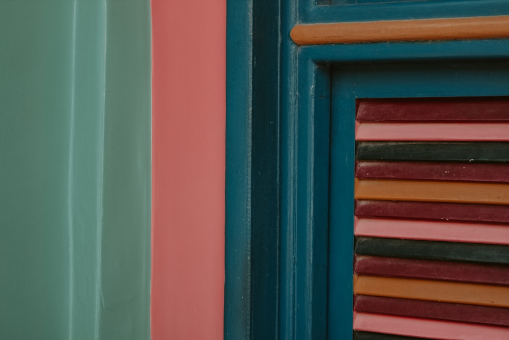 a close up of a window with different colored shutters