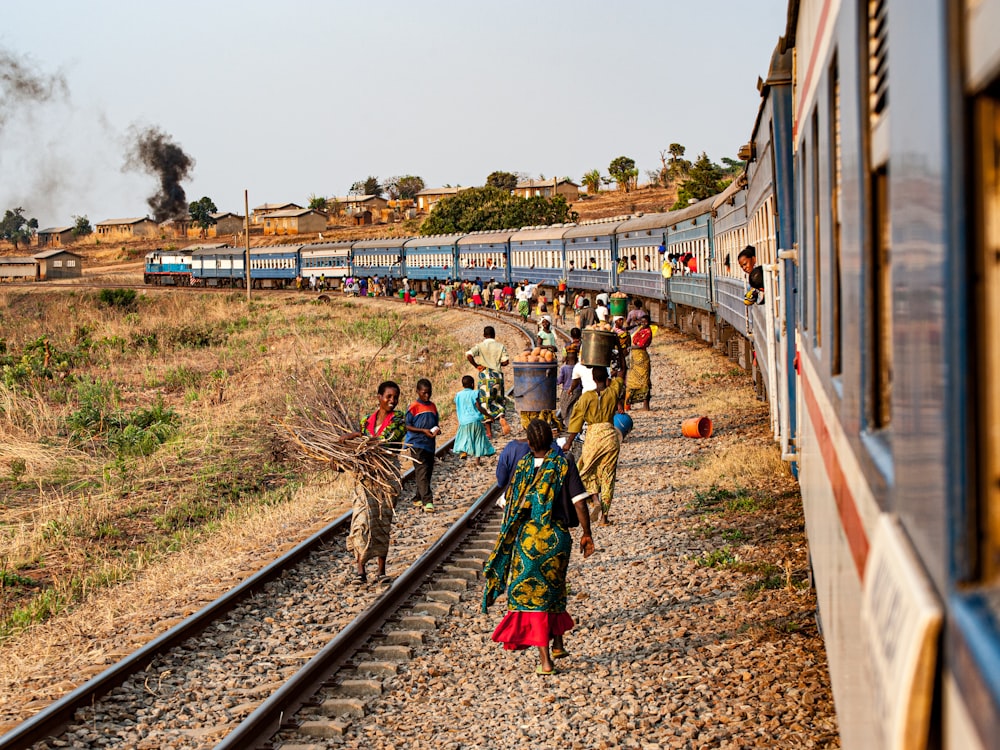 a group of people walking on a train track