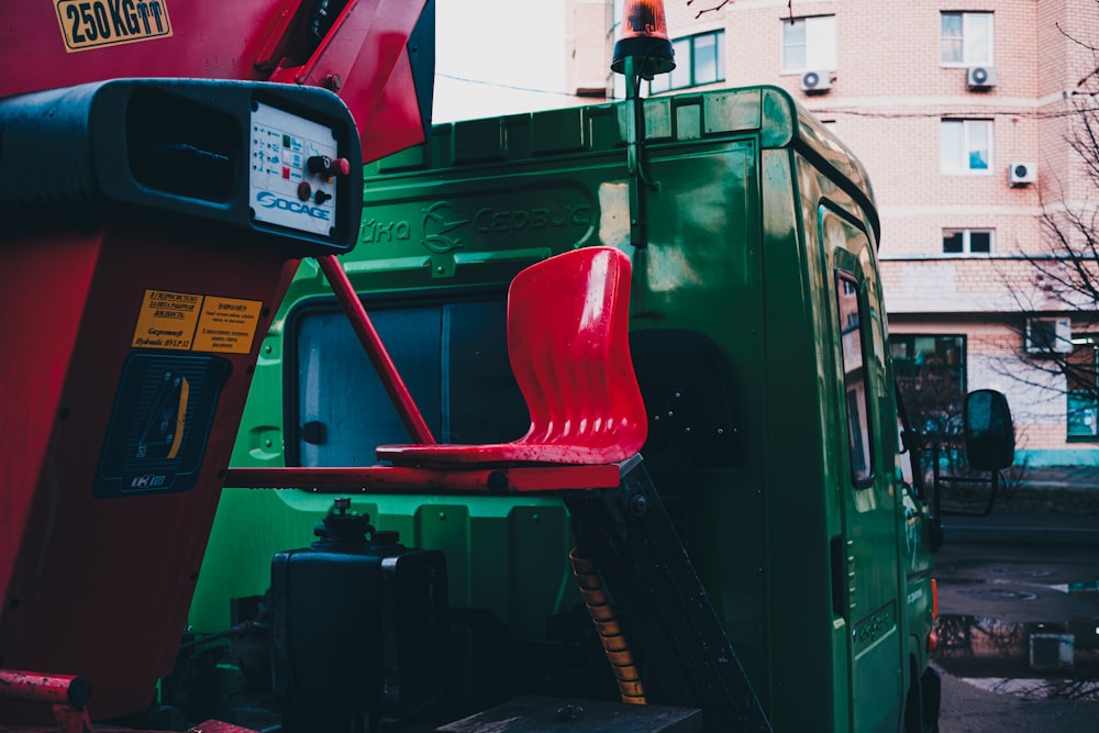 a red chair sitting on top of a green truck