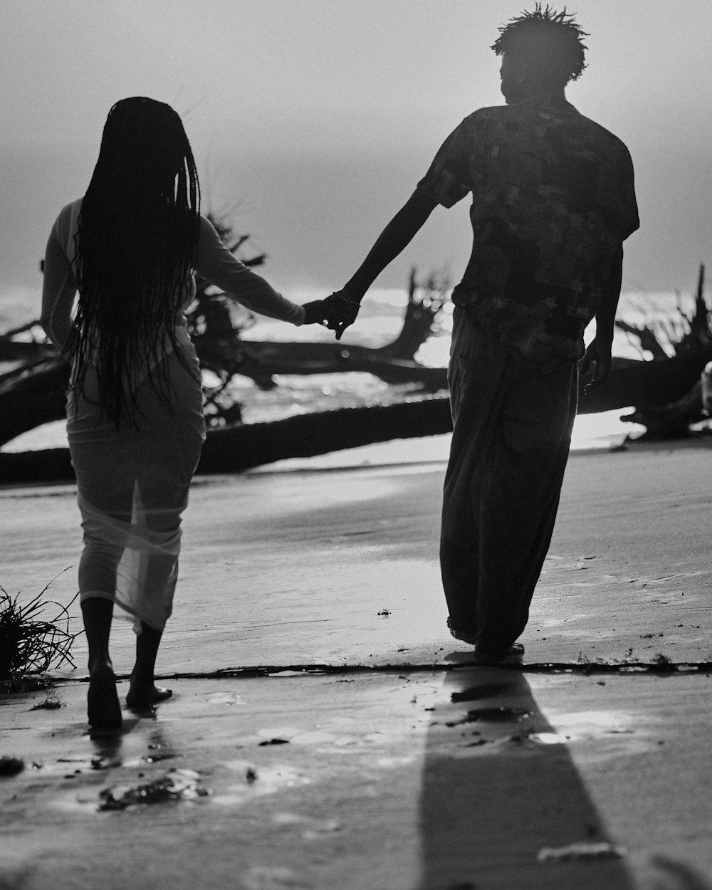 a man and a woman holding hands on a beach