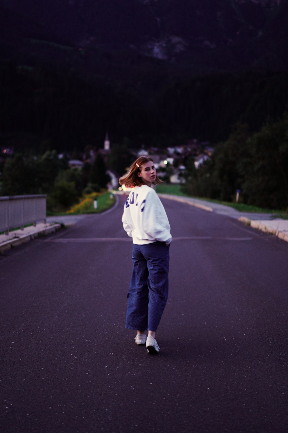 a woman standing in the middle of a road