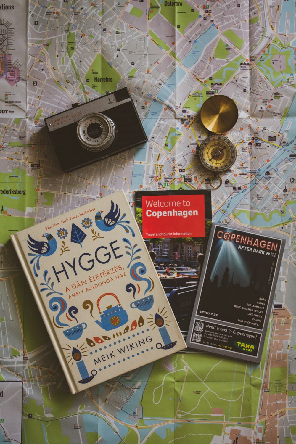 a map, a camera, and a book on a table