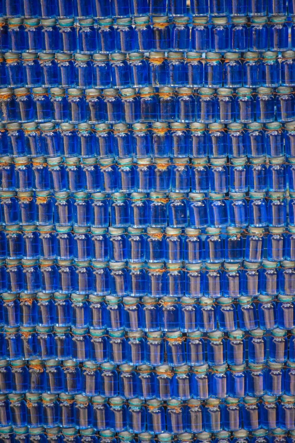 a close up of a wall made of blue glass bottles
