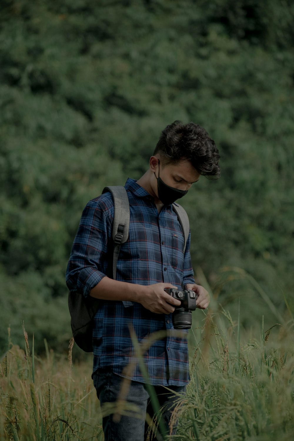 a man in a plaid shirt is holding a camera