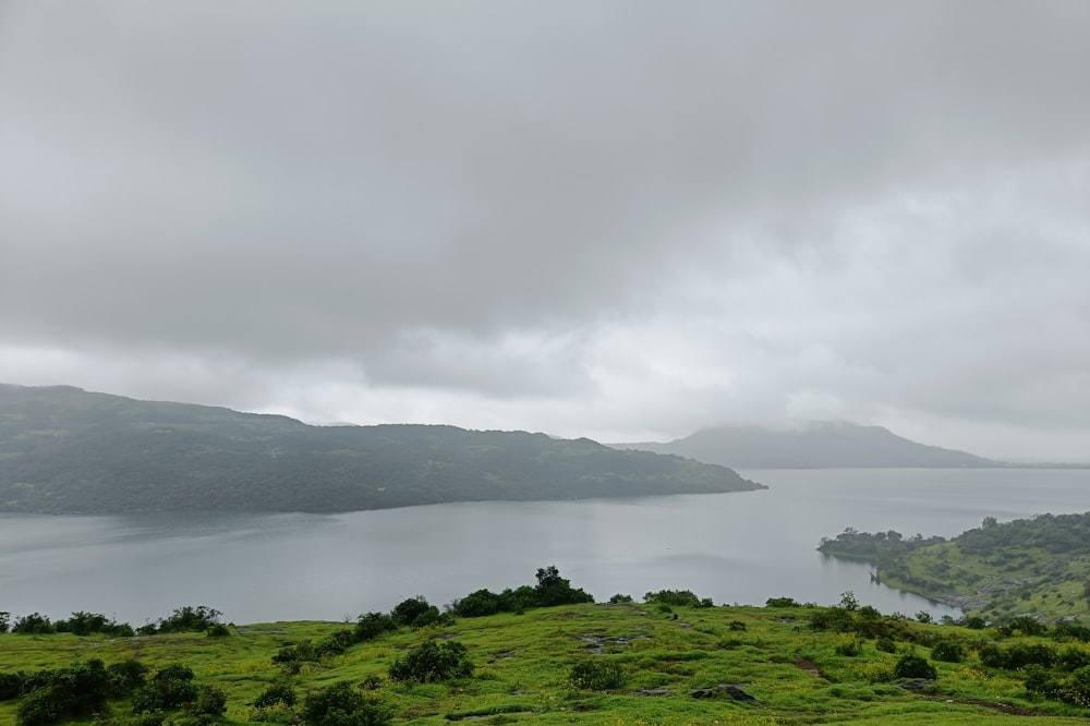 a large body of water surrounded by lush green hills