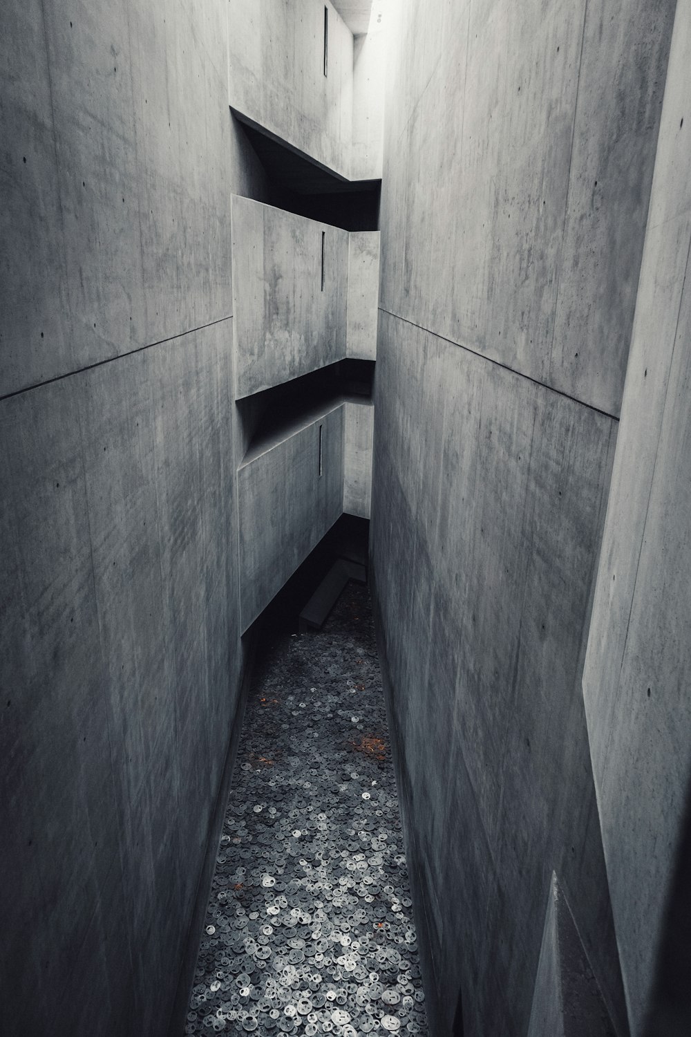 a narrow hallway with concrete walls and a concrete floor