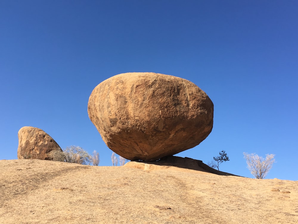 Ein großer Felsen auf einem sandigen Hügel