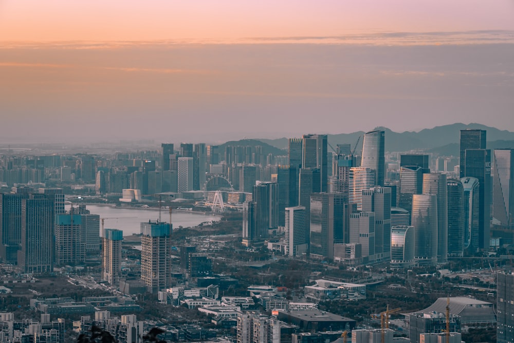 a view of a city with a lake and mountains in the background