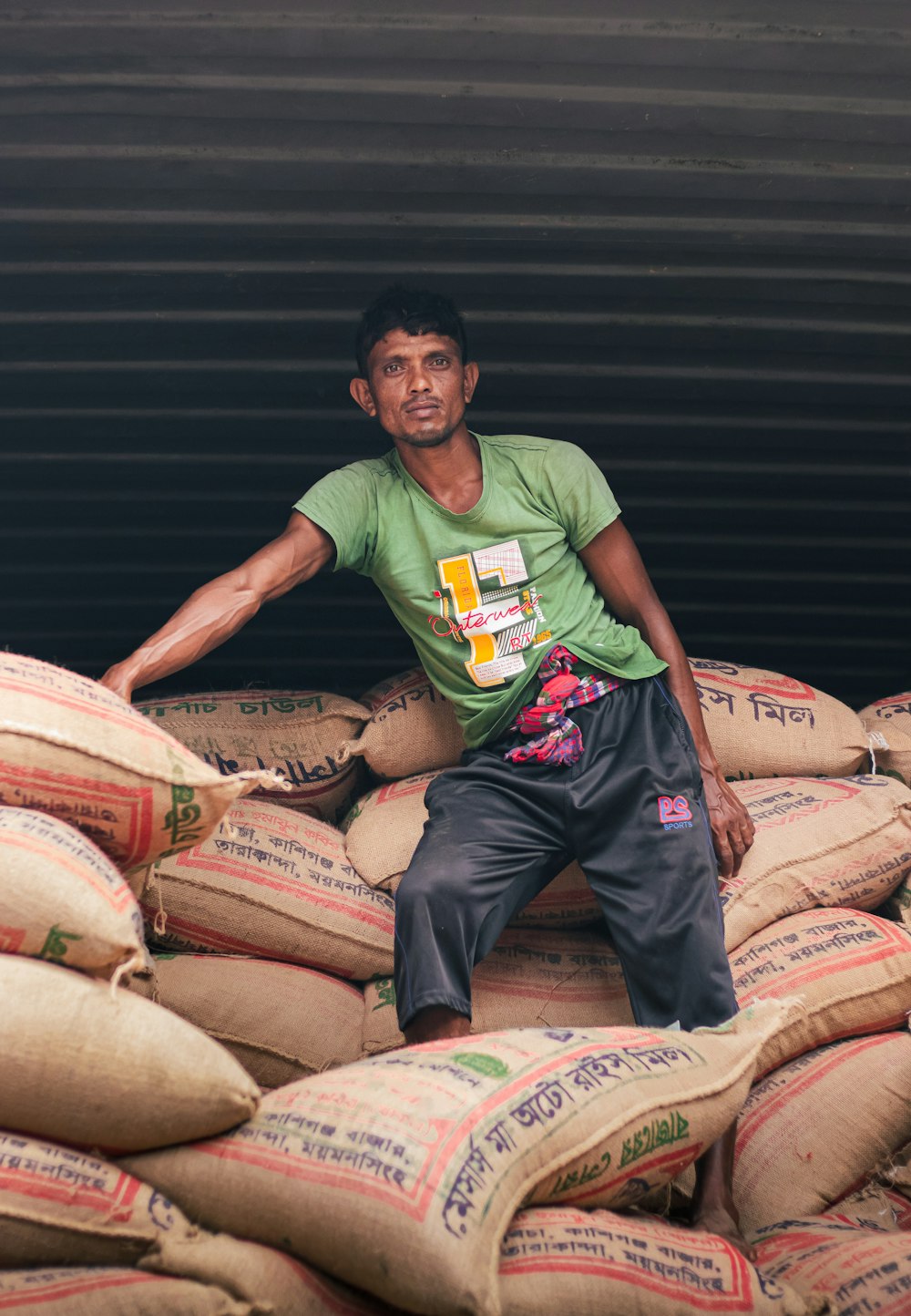 a man sitting on top of a pile of bags