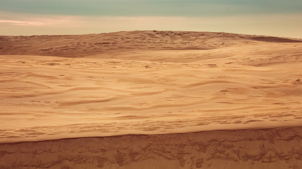 a person riding a surfboard on top of a sandy beach