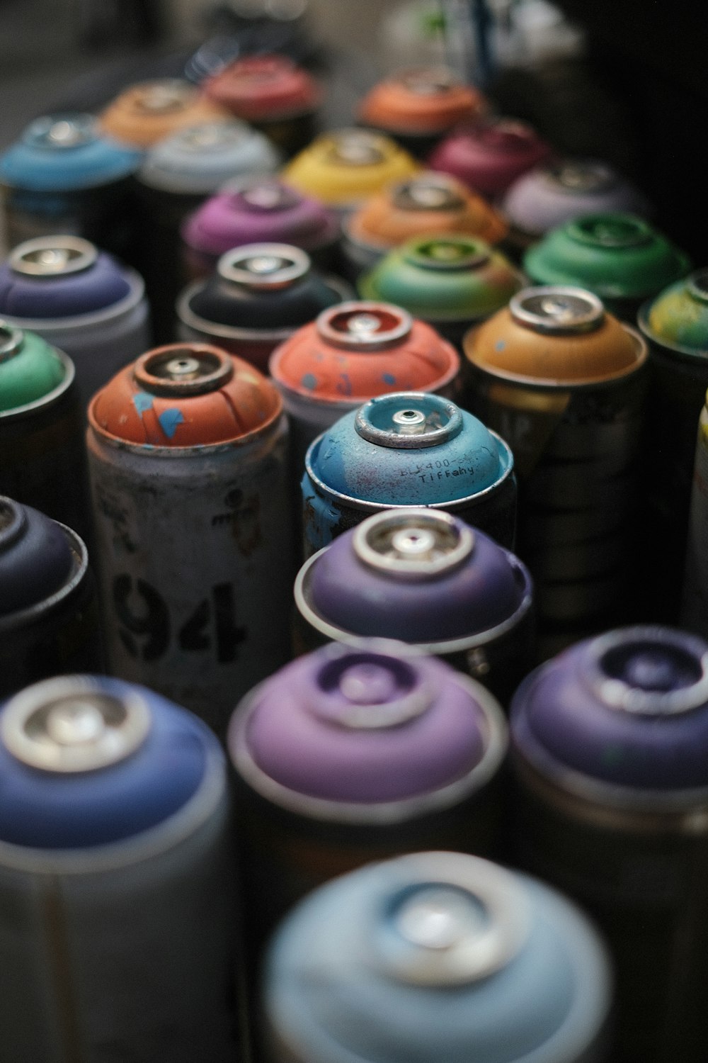 a bunch of different colored cans sitting next to each other