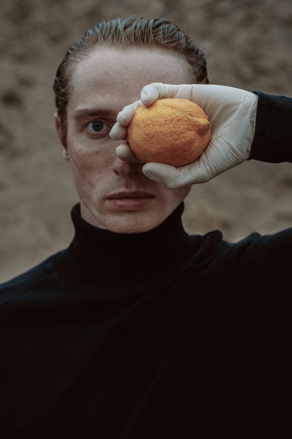 a woman in a black turtle neck holding an orange