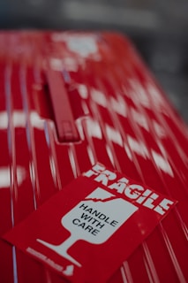 a close up of a red car with a sticker on it