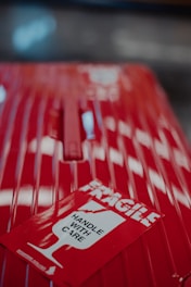 a red piece of luggage with a sticker on it