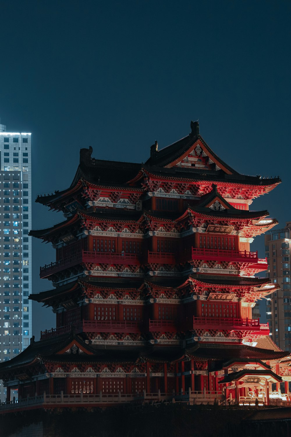 a tall building lit up at night in a city